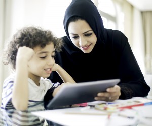 Middle eastern mother helping her child with homework.