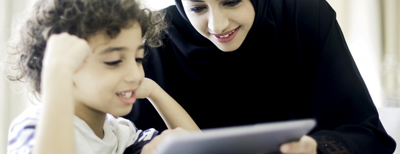 Middle eastern mother helping her child with homework.